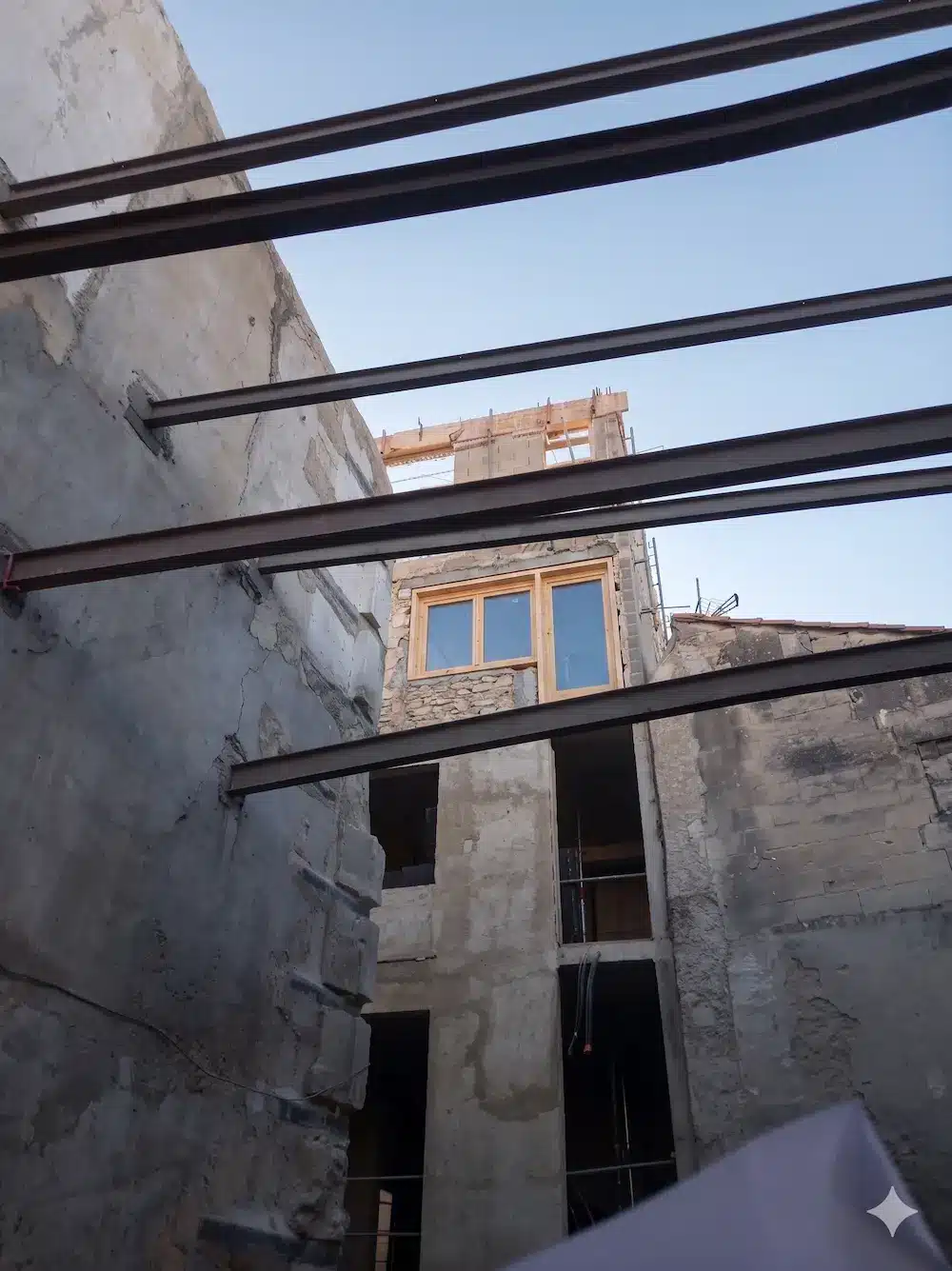 1) Texte alternatif:
Cour intérieure en réhabilitation lourde avec poutres métalliques, murs en pierre apparente et menuiserie bois.2) Légende:
Chantier de réhabilitation lourde d’un bâti en pierre: renforts par poutres métalliques et pose de fenêtre bois.3) Nom de fichier:
rehabilitation-lourde-poutres-metalliques-murs-pierre-mariani-btp.jpg